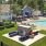 a building with a pool and trees and lounge area