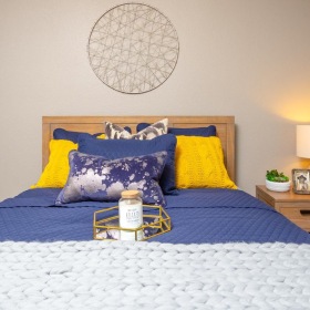 a bed with a blue and yellow bed spread