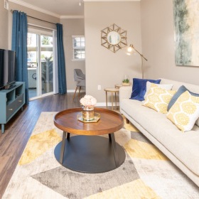 a living room with a couch and a table and tv and large window